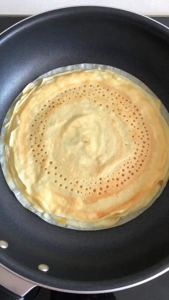 top view of a nonstick crepe pan with one lacy crepe